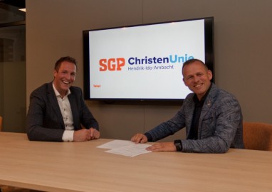Hendrik-Ido-Ambacht - De beide voorzitters, Robert Jan de Leede (links) van de SGP en Jan Dorst van de ChristenUnie, ondertekenen de samenwerkingsovereenkomst. Foto: SGP-ChristenUnie